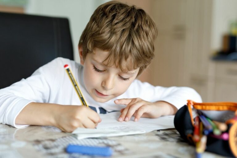 Young boy sitting at a table doing homework