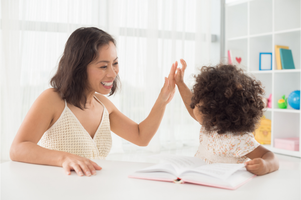 Mom giving daughter a high five while smiling